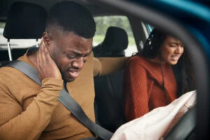 A passenger shows signs of whiplash after a car accident.