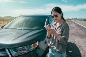 Woman tapping on her phone after a Rideshare Accident