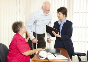 A Personal Injury Attorney reviewing a document with an injured man