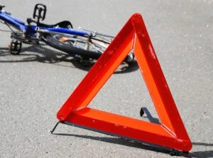 A triangle in the road close to a bike that was involved in an accident