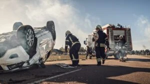 Rescue team of firefighters approaching to car involved in Catastrophic Accident