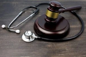Gavel and stethoscope on black wooden background ilustrating the concept of Medical Malpractice
