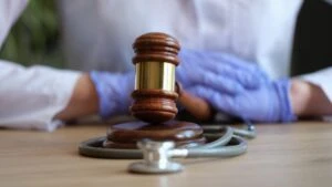 Close-up of female hands in gloves striking with judge hammer ilustrating the concept of Personal Injury Lawyer