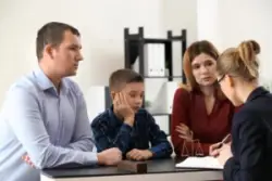a young boy and his parents consulting with a female attorney