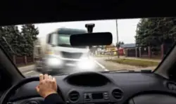 A commercial truck veering into the path of an oncoming car before a head-on collision.