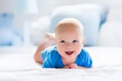 A newborn baby boy laughs. Contact an Emeryville birth injury lawyer.