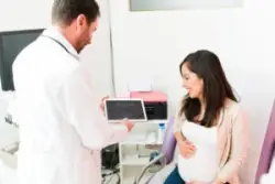 A pregnant woman visits her OBGYN. Contact a California OBGYN malpractice lawyer now.