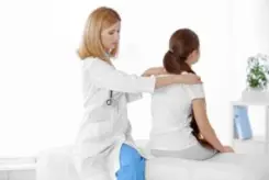 doctor examining woman’s spine