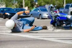 motorcycle rider lying in road after accident