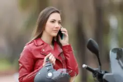 A motorcyclist on her cell phone