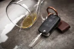a spilled glass of alcohol near a car key