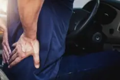 driver gripping their back after a car accident
