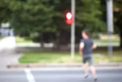 jogger crossing the street at a red stop signal