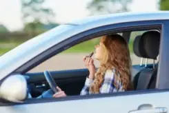 woman doing her make-up behind the wheel