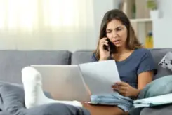 woman going over her medical bills on the phone