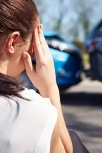 woman rubbing her head after an accident