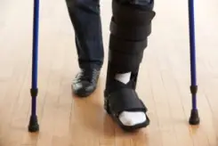 man walking with crutches with his foot in a cast