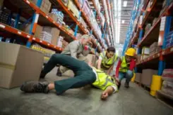 trabajadores ayudan a colega herido en almacén