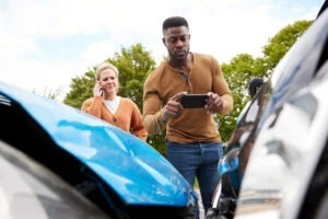 man taking pictures after car accident