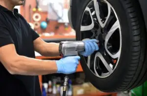 mechanic screwdriver repairing car wheel