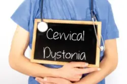Doctor holding sign that says cervical dystonia