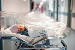 A baby in a plastic crib in the hospital