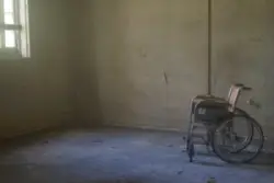A wheel chair in a dilapated room
