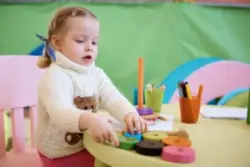 A child with erbs palsy playing with toys