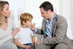 A child and parent speaking with a doctor
