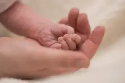 Parent holds their baby close