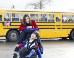 A mother pushing a child with cerebral palsy in their wheelchair
