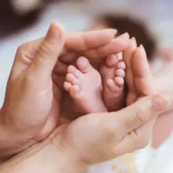 an infants feet held by two hands