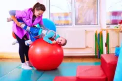 A child with Cerebral Palsy balancing on a ball