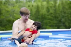 A father holding his child with Cerebral Palsy in a pool