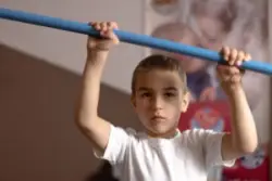 A child lifting up a blue bar