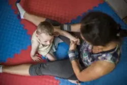 A child and adult playing on mats