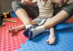 A child with cerebral palsy sitting with an adult