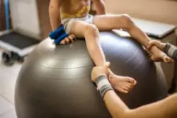 A child with cerebral palsy sitting on a stabilizing ball
