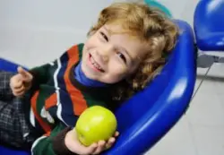 A child with cerebral palsy holding an apple