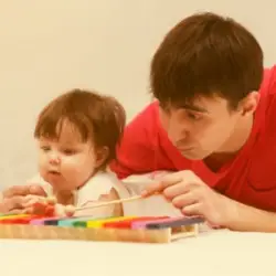 A child with erbs palsy playing a xylophone with an adult