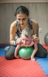 A child with erbs palsy doing yoga