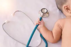 baby clutching a stethoscope