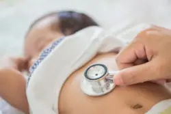 doctor examining baby with stethoscope