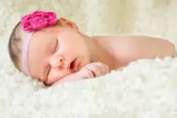 newborn sleeping on arms