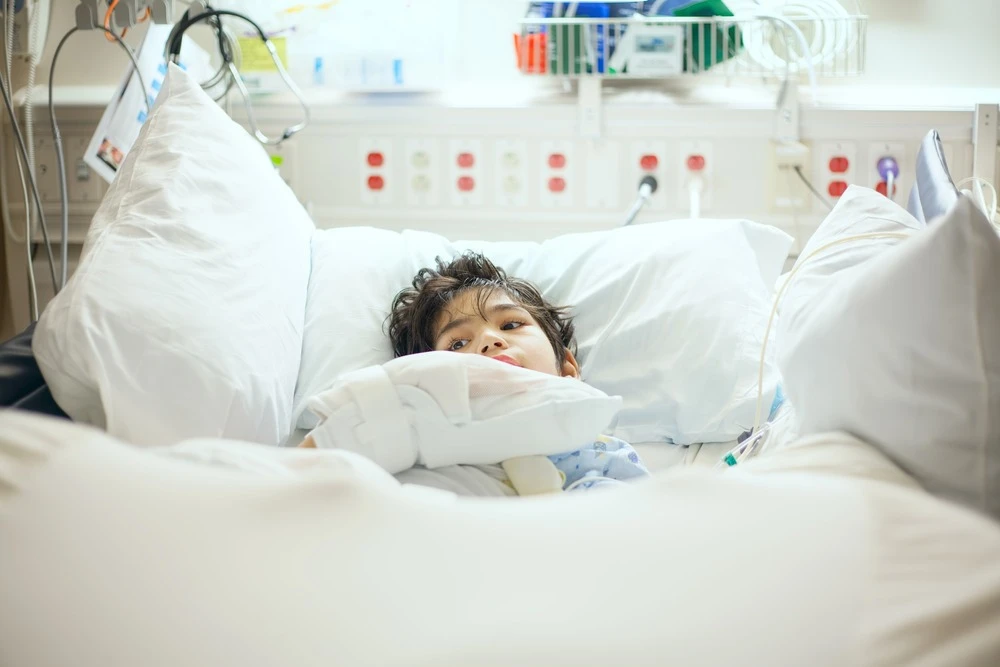 A child with cerebral palsy lies in a hospital bed.