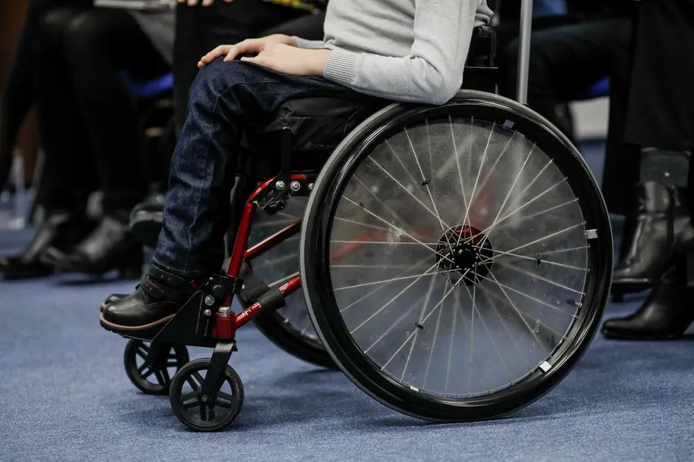 A young child with cerebral palsy sits in a wheelchair.