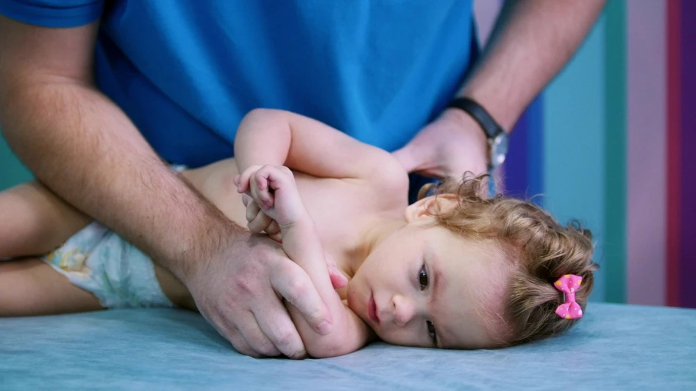 baby with cerebral palsy undergoes physiotherapy