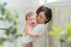 mother tries to soothe her crying baby