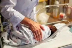 Nurse is running tests on a newborn
