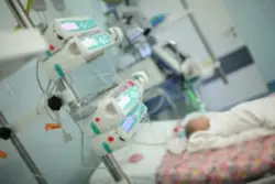 multiple medical instruments monitor baby in intensive care unit